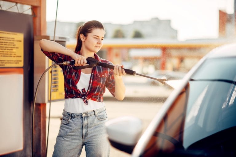 Young woman on self-service car wash